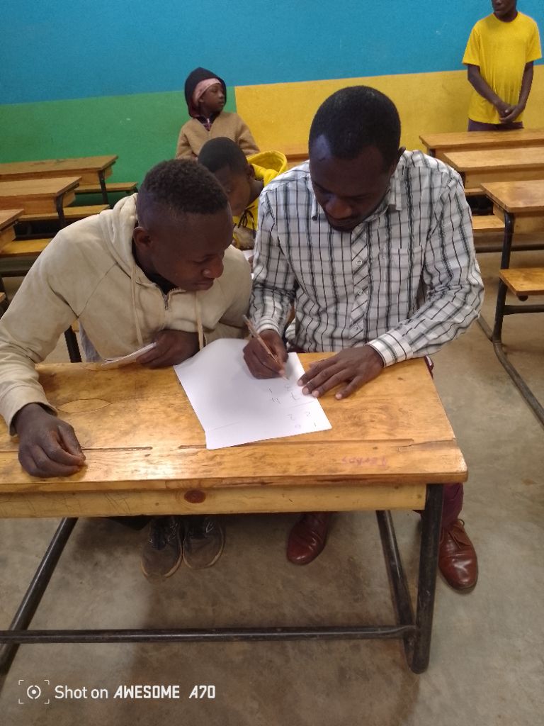 Learners working together at a desk in class